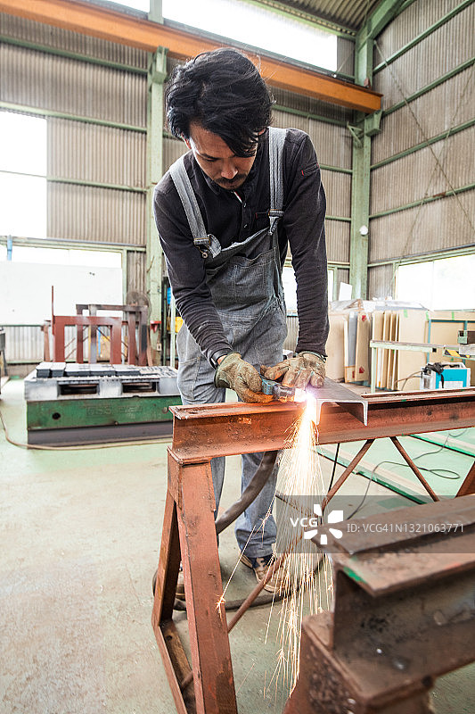 一名日本金属工人在工厂使用等离子切割机图片素材