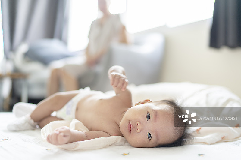 亚洲新生儿（1-3个月）和妈妈在洗澡后换尿布，非常开心图片素材