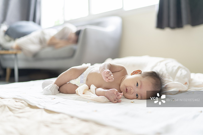 亚洲新生儿（1-3个月）和妈妈在洗澡后换尿布，非常开心图片素材