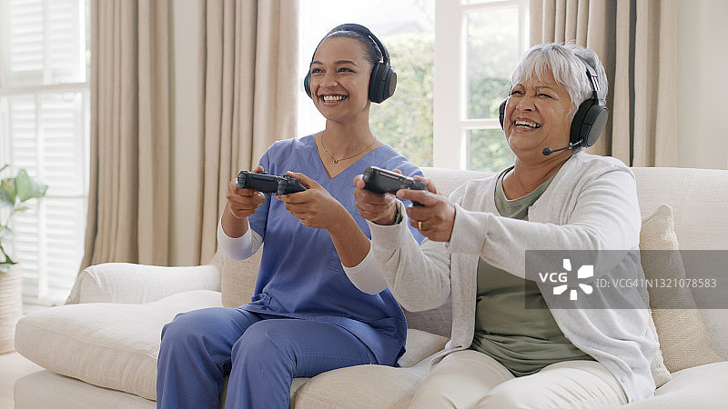 老年妇女在家与护士一起玩游戏图片素材