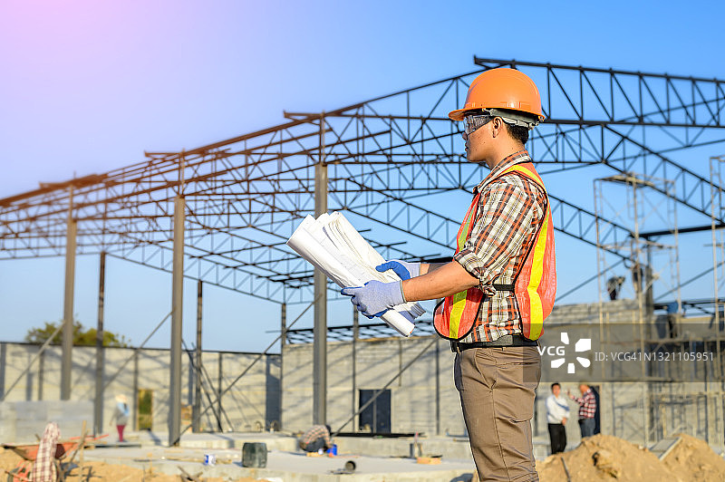 工程师在泰国建筑工地上查看建筑蓝图图片素材