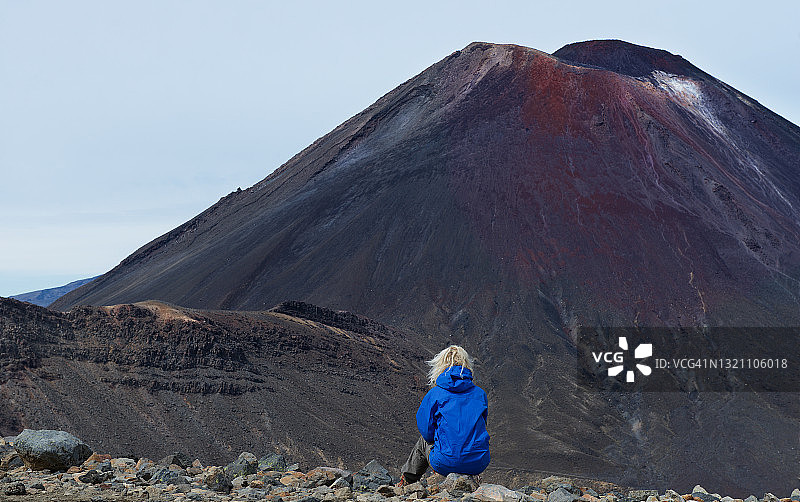 女子坐在岩石上眺望火山的背影，新西兰汤加里罗国家公园北岛图片素材