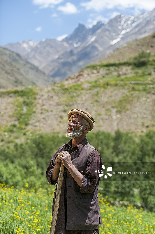 农民走过油菜花和小麦田图片素材