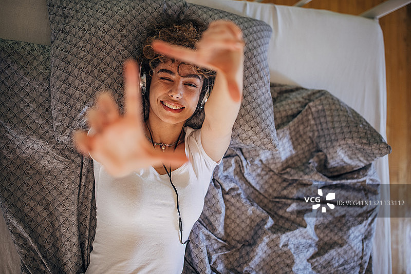 美丽女人在床上听音乐图片素材