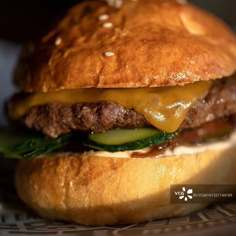 经典美式汉堡配融化的奶酪、肉和新鲜黄瓜图片素材