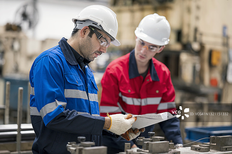 质量控制工程师向生产线车间的质量人员讲解工程零件检验的工作指导书标准。质量控制保证概念。汽车行业的人力资源管理图片素材