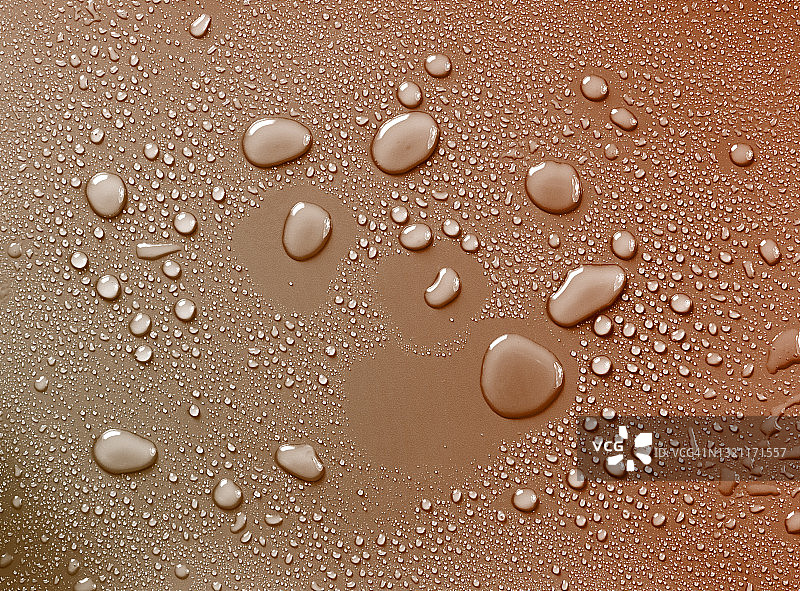 棕色背景上的水滴和水花图片素材