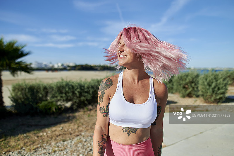 户外甩动粉色头发的运动型女子肖像图片素材