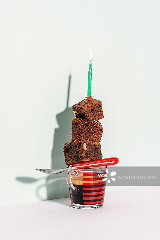 红色复古杯中的生日浓缩咖啡、红色勺子和巧克力布朗尼图片素材