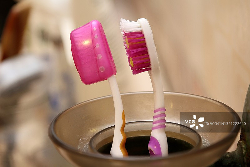带和不带盖的牙刷在浴室支架中图片素材