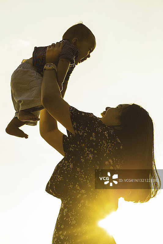 亚洲年轻母亲携带婴儿的轮廓图片素材