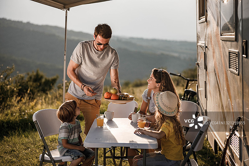 幸福家庭在野外露营车旁野餐图片素材