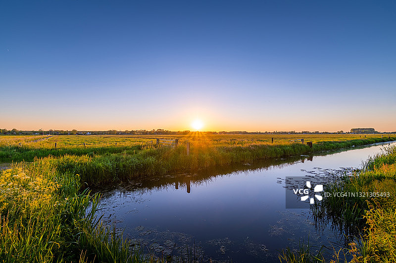 日落时分的草地和河流景观图片素材