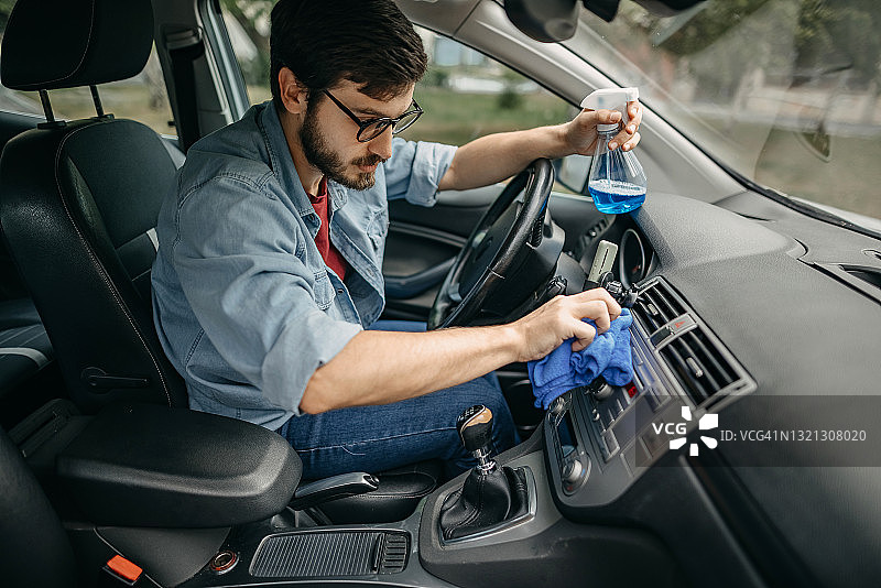 年轻人用湿巾清洁汽车内饰图片素材