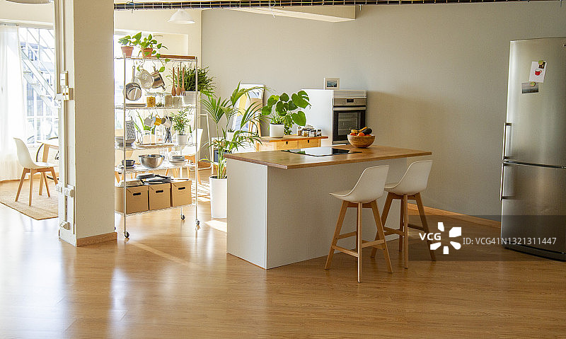 工业开放式阁楼中的北欧风格开放式厨房，配有白色和木制家具以及灰色背景墙图片素材