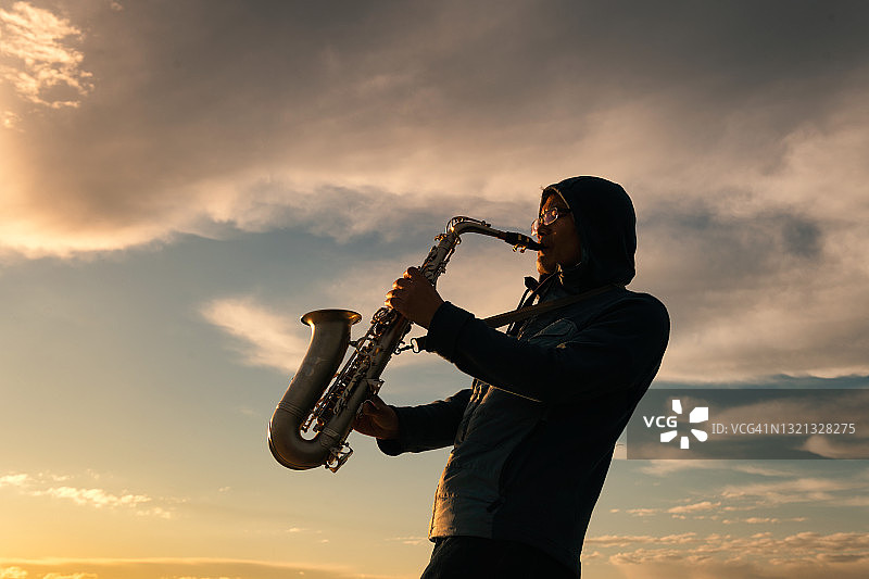 在海边演奏萨克斯的乐手图片素材