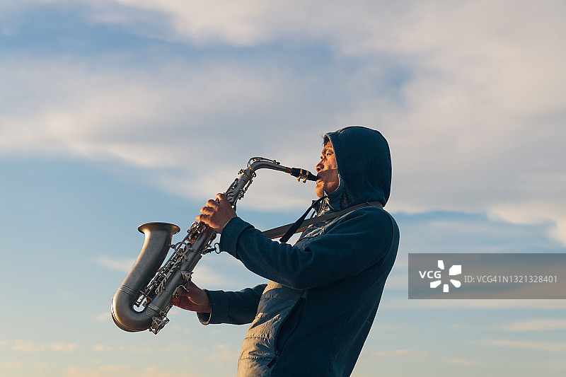 在海边演奏萨克斯的乐手图片素材