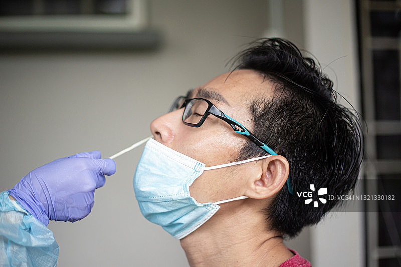 亚洲中国男人在诊所进行PCR检测特写图片素材