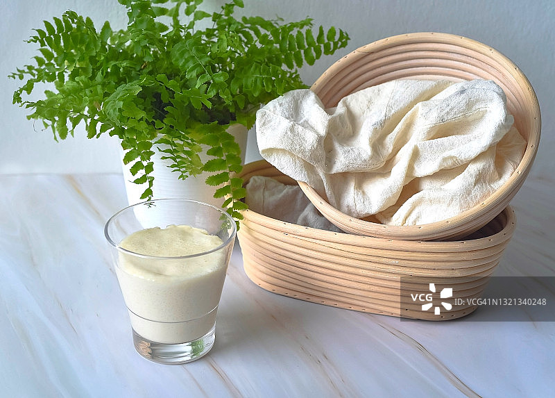 玻璃杯中的酵母和两个发酵篮特写图片素材