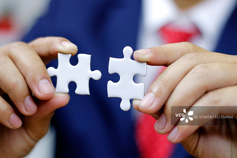 商业解决方案、成功和战略概念。商人连接拼图。图片素材