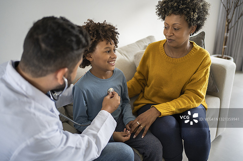 医生用听诊器检查孩子。新冠疫情期间的家庭医疗保健图片素材