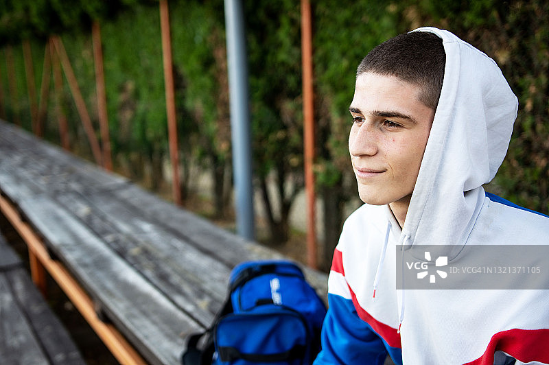 坐在长凳上的年轻棒球运动员图片素材