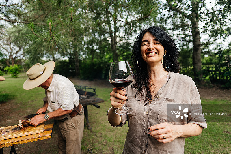 在阿根廷烧烤会上用葡萄酒祝酒的女人图片素材