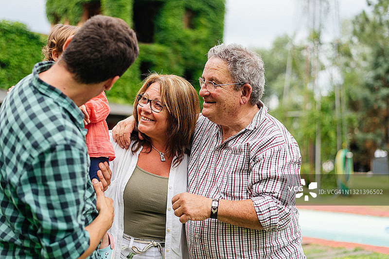 父亲和祖父母在后院见面图片素材