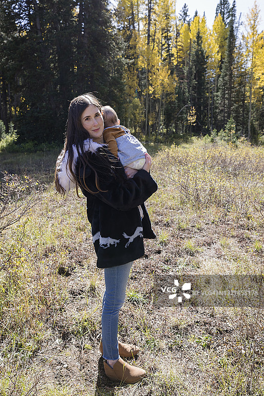 一位母亲抱着女儿站在美国加利福尼亚州的森林里图片素材