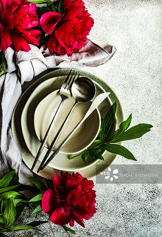餐桌上的餐具摆放和红色牡丹花俯视图图片素材