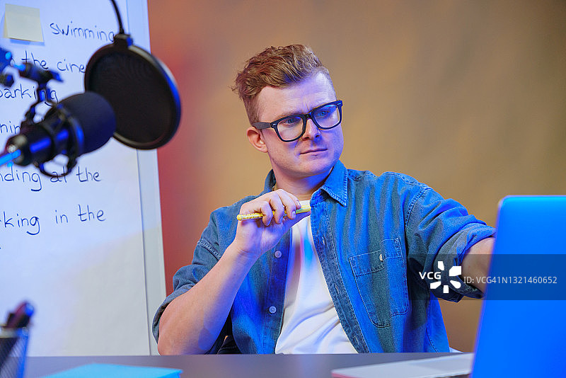 用笔记本电脑在线教学的金发男学生图片素材