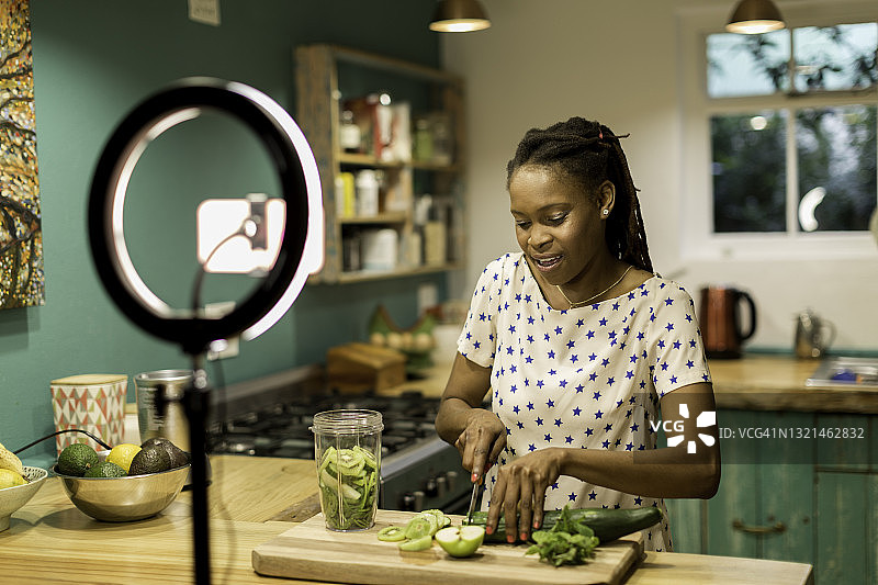 年轻的黑人女性制作健康饮食的视频博客图片素材