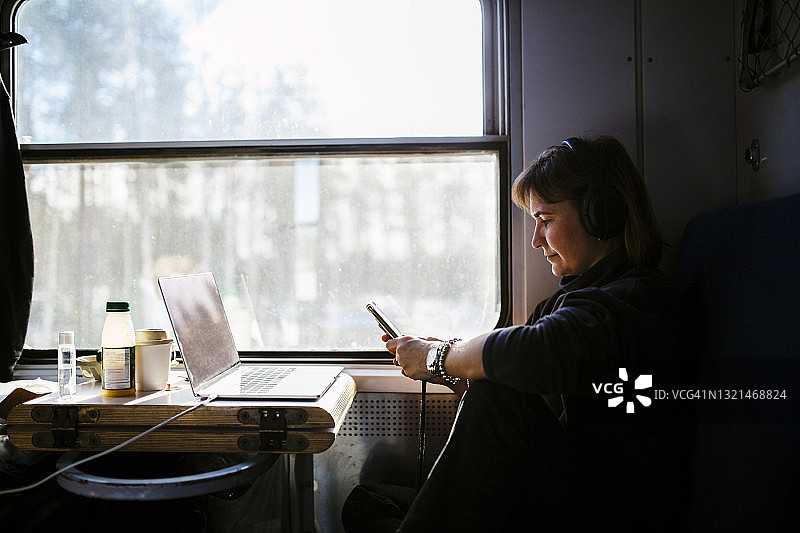 女人在火车上用智能手机发短信图片素材