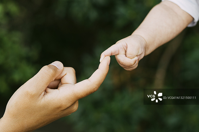 女人的手握着婴儿的手图片素材