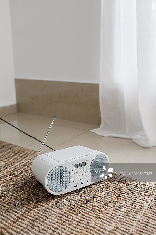 房间窗边黄麻地毯上的白色录音机图片素材