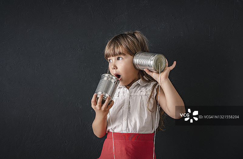 用罐头盒电话收听好奇的好消息图片素材
