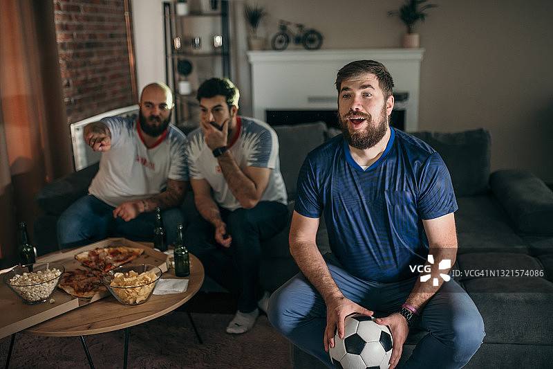 朋友们在电视上看体育比赛图片素材