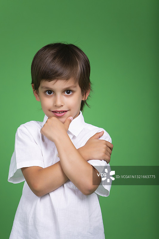可爱的男孩站着看向镜头，手放在脸旁，色度键图片素材