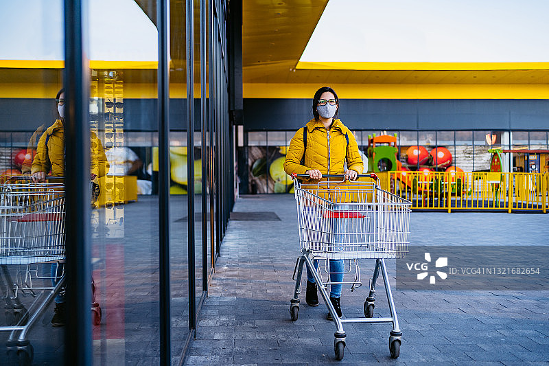 戴着口罩在杂货店购物的女人图片素材