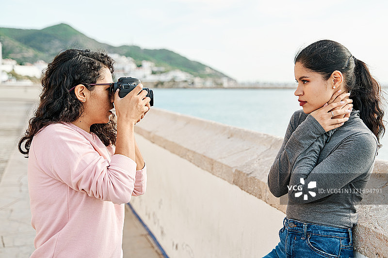 女摄影师在海边拍摄模特图片素材