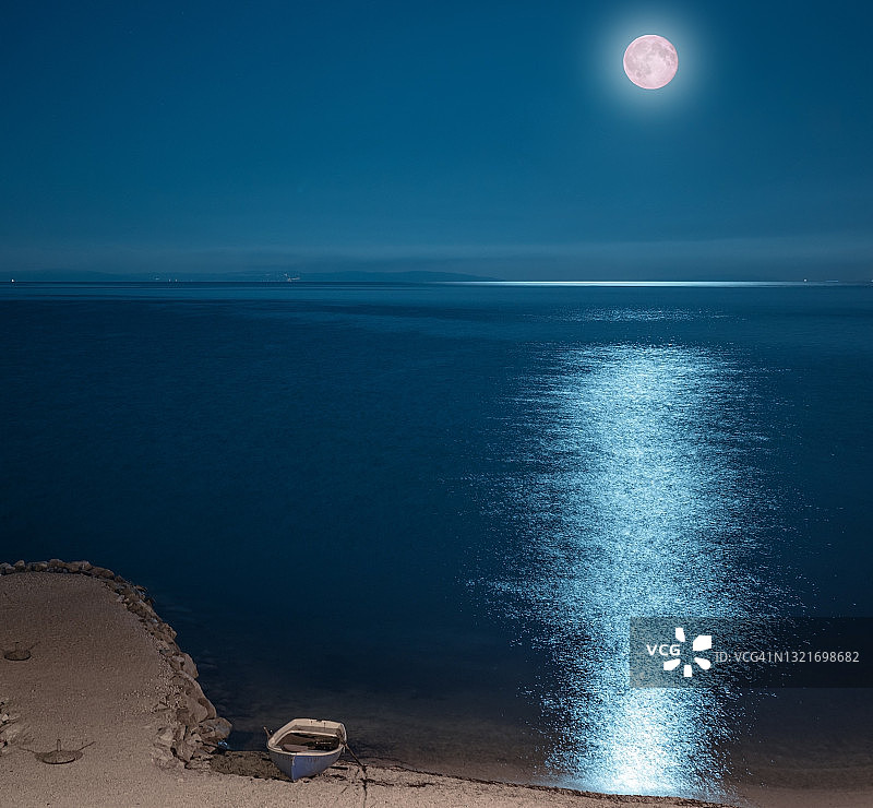 美丽的夜晚海滩、划艇、海洋和月光。克罗地亚波德斯特拉纳。图片素材