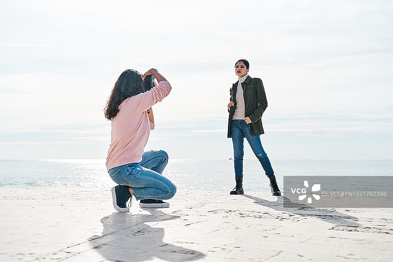 女摄影师在海边拍摄模特图片素材