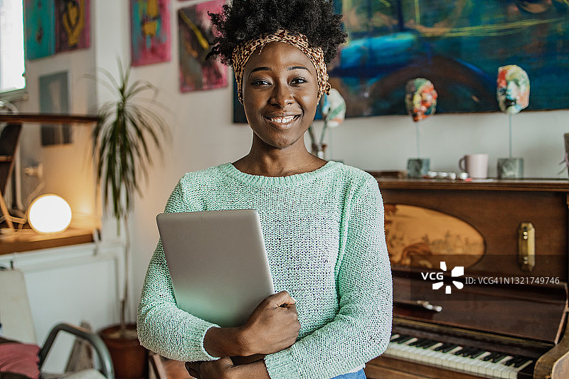 钢琴老师手持笔记本电脑的肖像图片素材