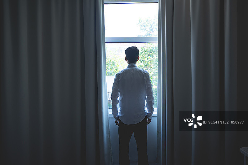 向窗外看的年轻男人图片素材