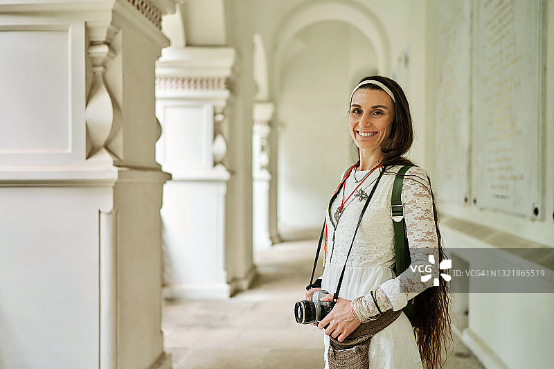 手持复古相机的漂亮女游客图片素材