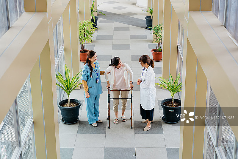 居家护理员帮助老年妇女使用助行器图片素材