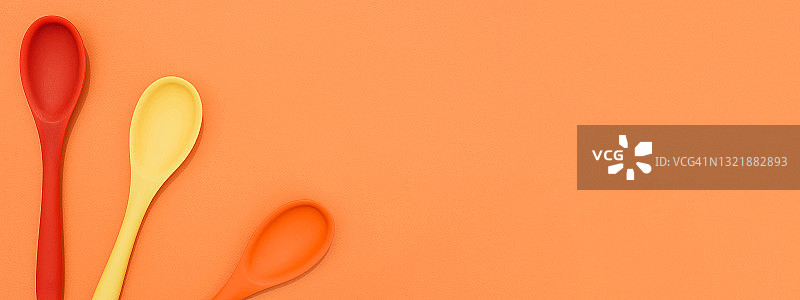 彩色背景上的明亮彩色勺子图片素材