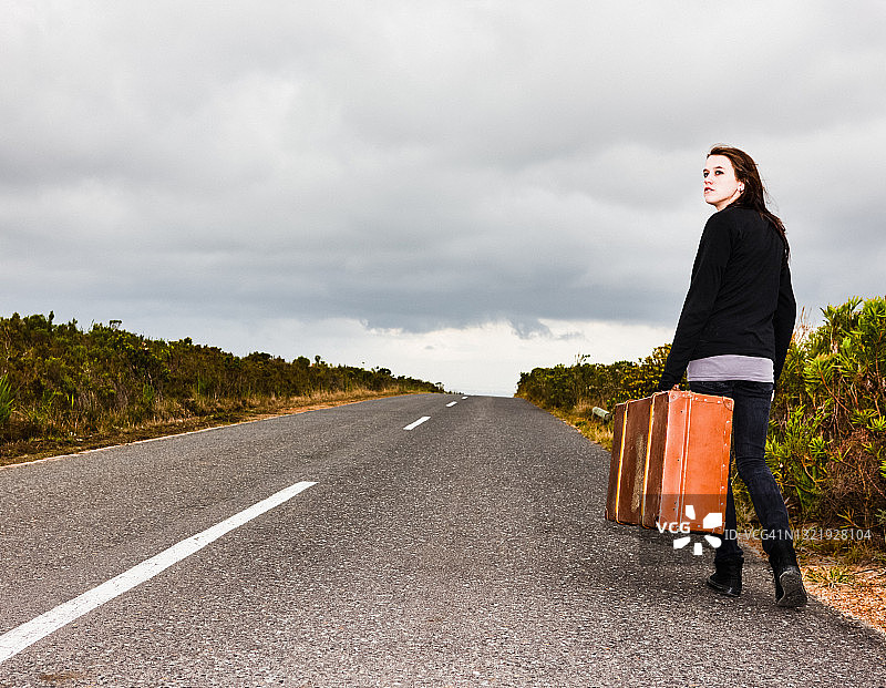 带着行李箱，选择自己的未来，可能正在逃离困境的年轻女人图片素材