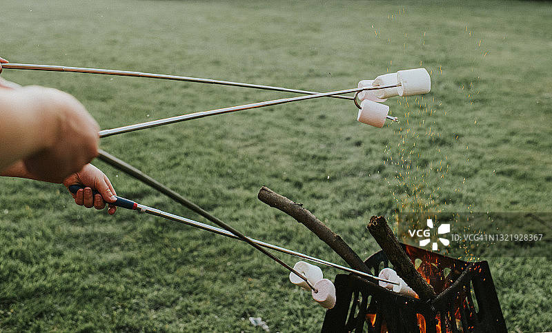 在黄昏的火坑上烤棉花糖图片素材