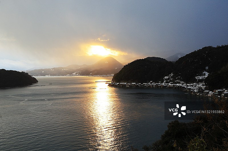 伊根湾日落景色——寒冷冬日傍晚，伊根舟屋被小雪覆盖图片素材